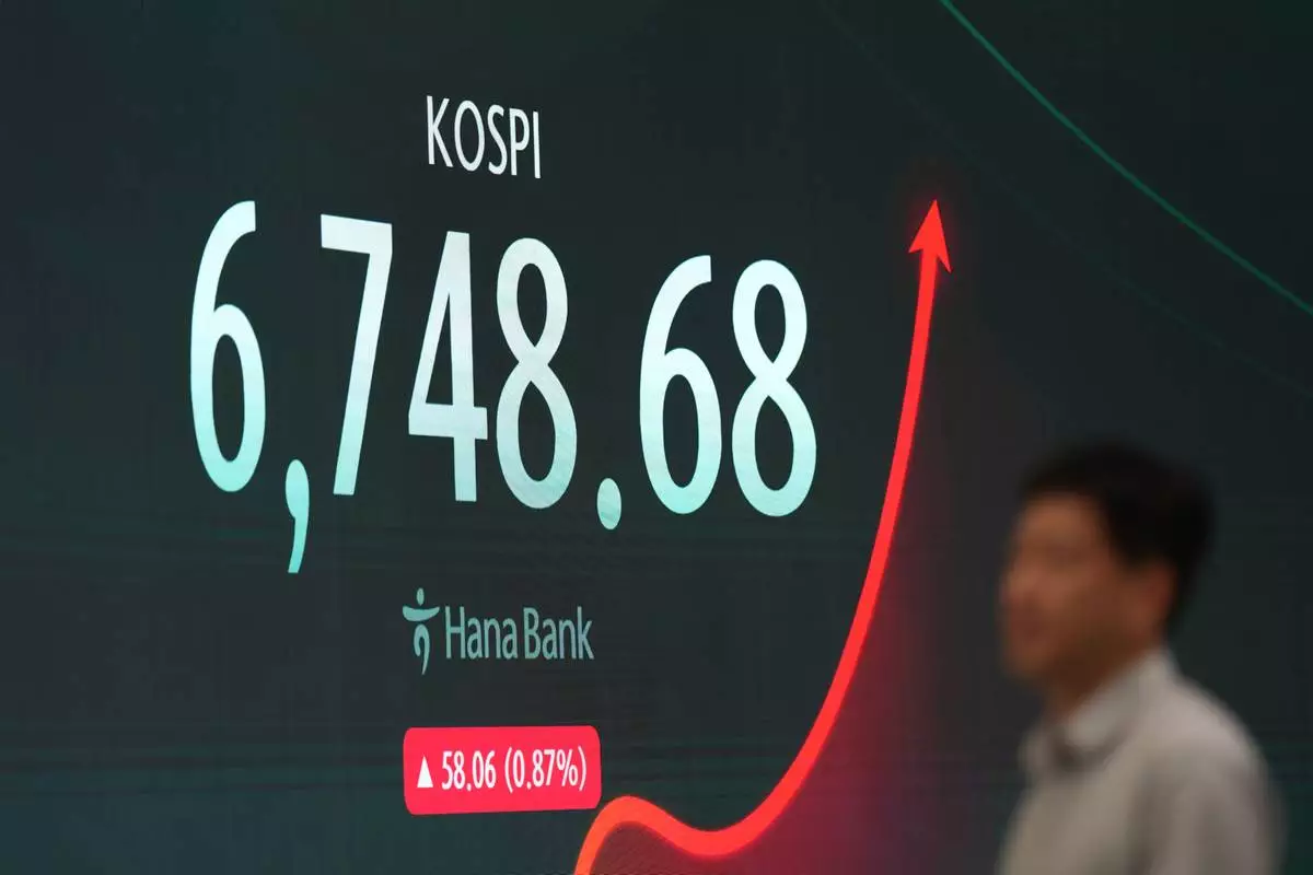 A dealer walks past near the screen showing the Korea Composite Stock Price Index (KOSPI) at a dealing room of Hana Bank in Seoul, South Korea, Monday, July 27, 2026. (AP Photo/Lee Jin-man)