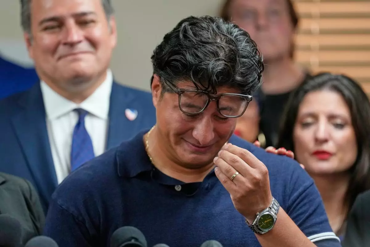 Ronaldo Salgado, son of Lorenzo Salgado Araujo, wipes away tears while speaking during a news conference Wednesday, July 8, 2026, in Houston. (AP Photo/David J. Phillip)
