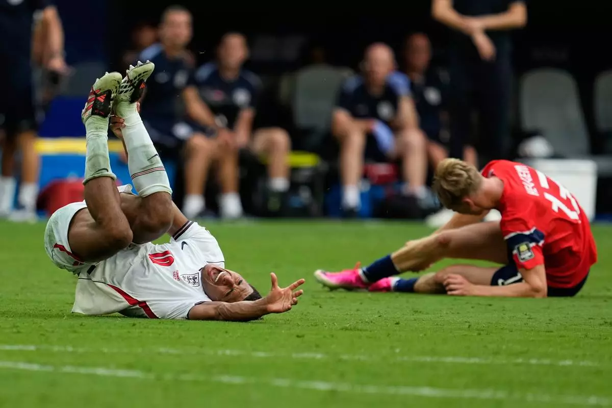 England's Jude Bellingham (10) grimaces in pain after clashing with Norway's Torbjoern Heggem (17) during the World Cup quarterfinal soccer match between Norway and England in Miami Gardens, Fla., Saturday, July 11, 2026. (AP Photo/George Walker IV)
