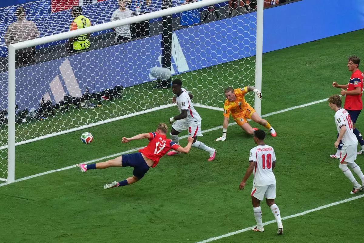 Norway's Torbjoern Heggem (17), right, scores a goal that was later disallowed as England's Marc Guehi (6) and goalkeeper Jordan Pickford (1) defend on the play during the World Cup quarterfinal soccer match between Norway and England in Miami Gardens, Fla., Saturday, July 11, 2026. (AP Photo/Marta Lavandier)
