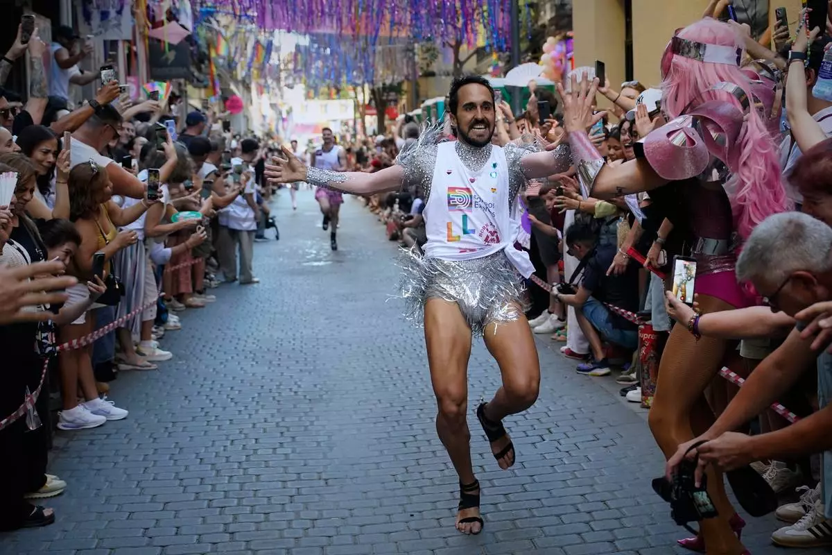 Participants wearing shoes with heels of at least 10 centimeters (3.9 inches) run in the annual high heel race during Madrid's Pride week, in Madrid, Thursday, July 2, 2026. (AP Photo/Andrea Comas)