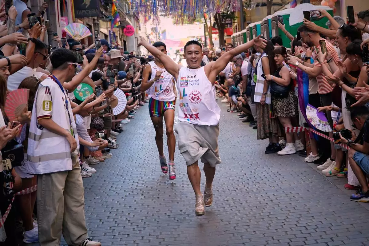 Participants wearing shoes with heels of at least 10 centimeters (3.9 inches) run in the annual high heel race during Madrid's Pride week, in Madrid, Thursday, July 2, 2026. (AP Photo/Andrea Comas)