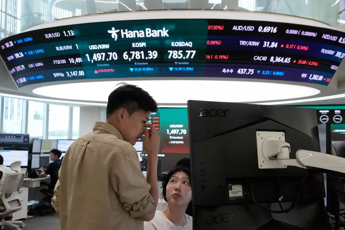 Currency traders work at the foreign exchange dealing room of the Hana Bank headquarters in Seoul, South Korea, Tuesday, July 14, 2026. (AP Photo/Ahn Young-joon)