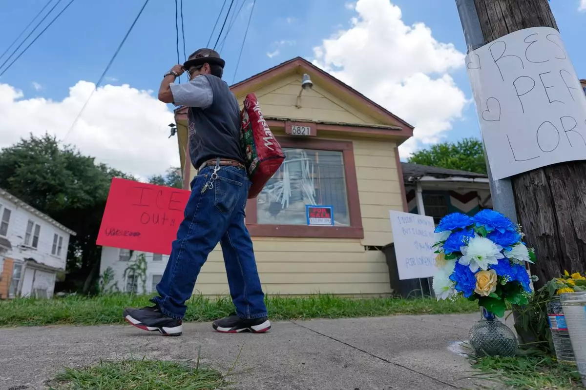 A man walks past a makeshift memorial for Lorenzo Salgado Araujo Wednesday, July 8, 2026, in Houston. (AP Photo/David J. Phillip)