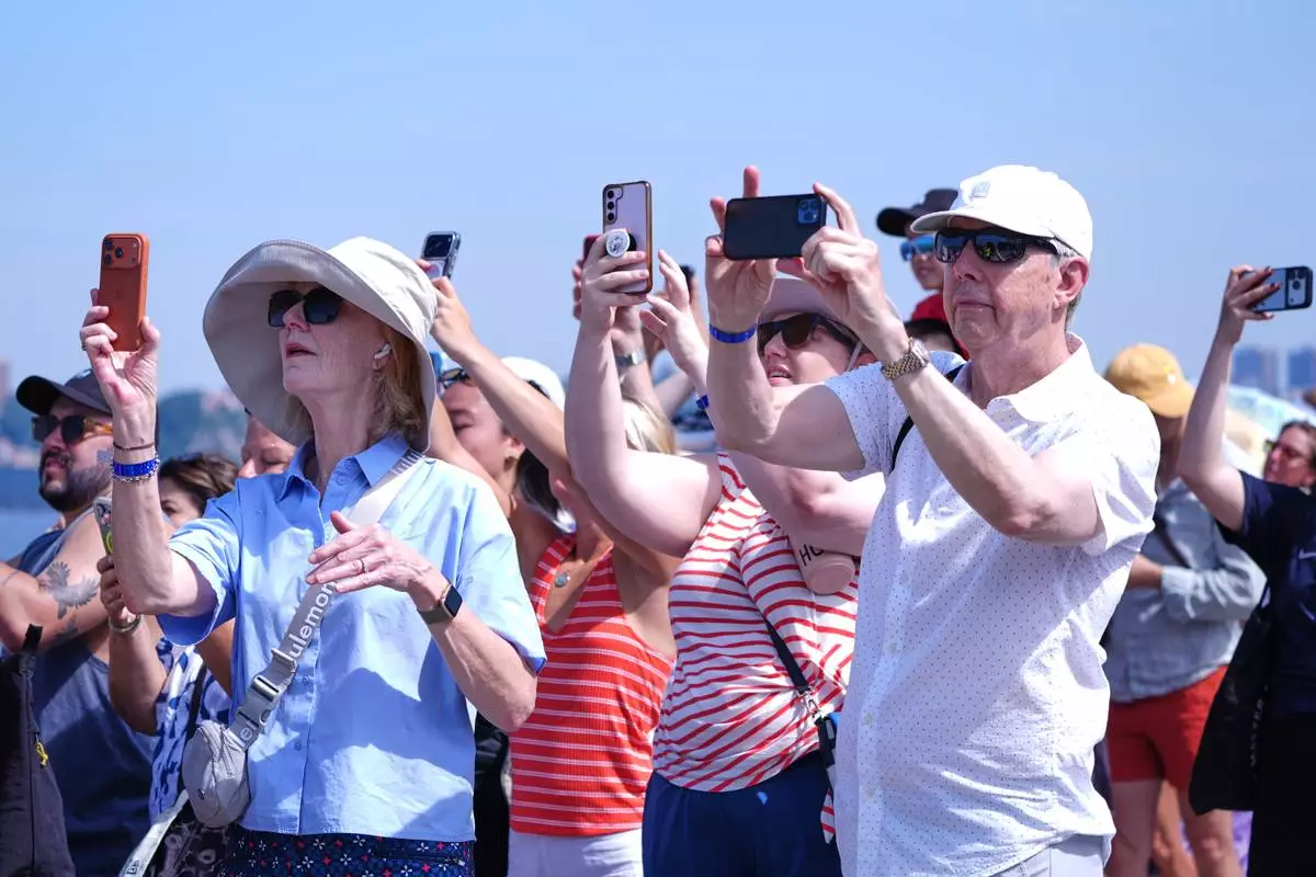 People watch as the French Air Force acrobatic squad Patrouille de France perform a flyover during the International Aerial Review, Saturday, July 4, 2026, in New York. (AP Photo/Sydney Schaefer)