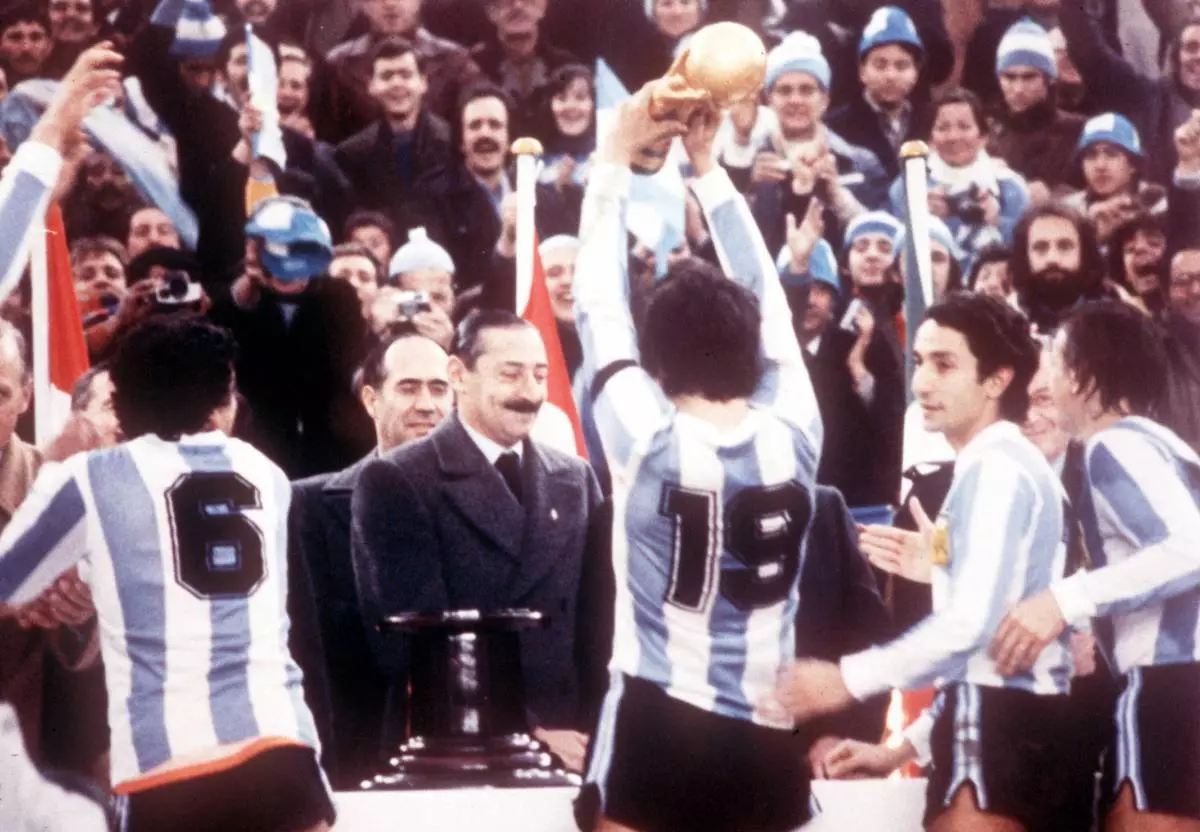 FILE - Argentine President Jorge Rafael Videla, center, looks on after he presented the World Cup Trophy to Argentina's captain Daniel Passarella (19), at the presentation ceremony following the World Cup final soccer match against the Netherlands in the River Plate Stadium in Buenos Aires, June 25, 1978. (AP Photo/Heinz Ducklau)