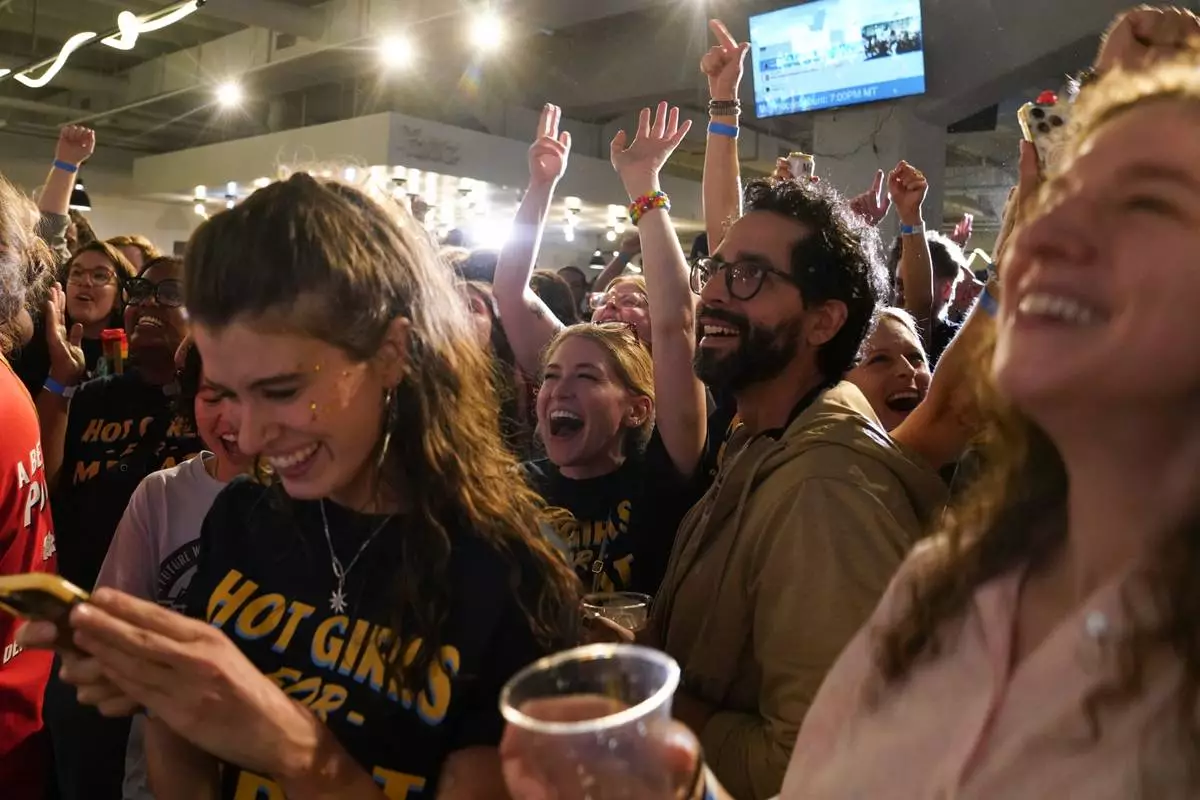 Supporters cheer as the second round of results come in with Democratic congressional candidate Melat Kiros leading during an election night watch party at The Broadway, Tuesday, June 30, 2026, in Denver. (AP Photo/Rebecca Slezak)