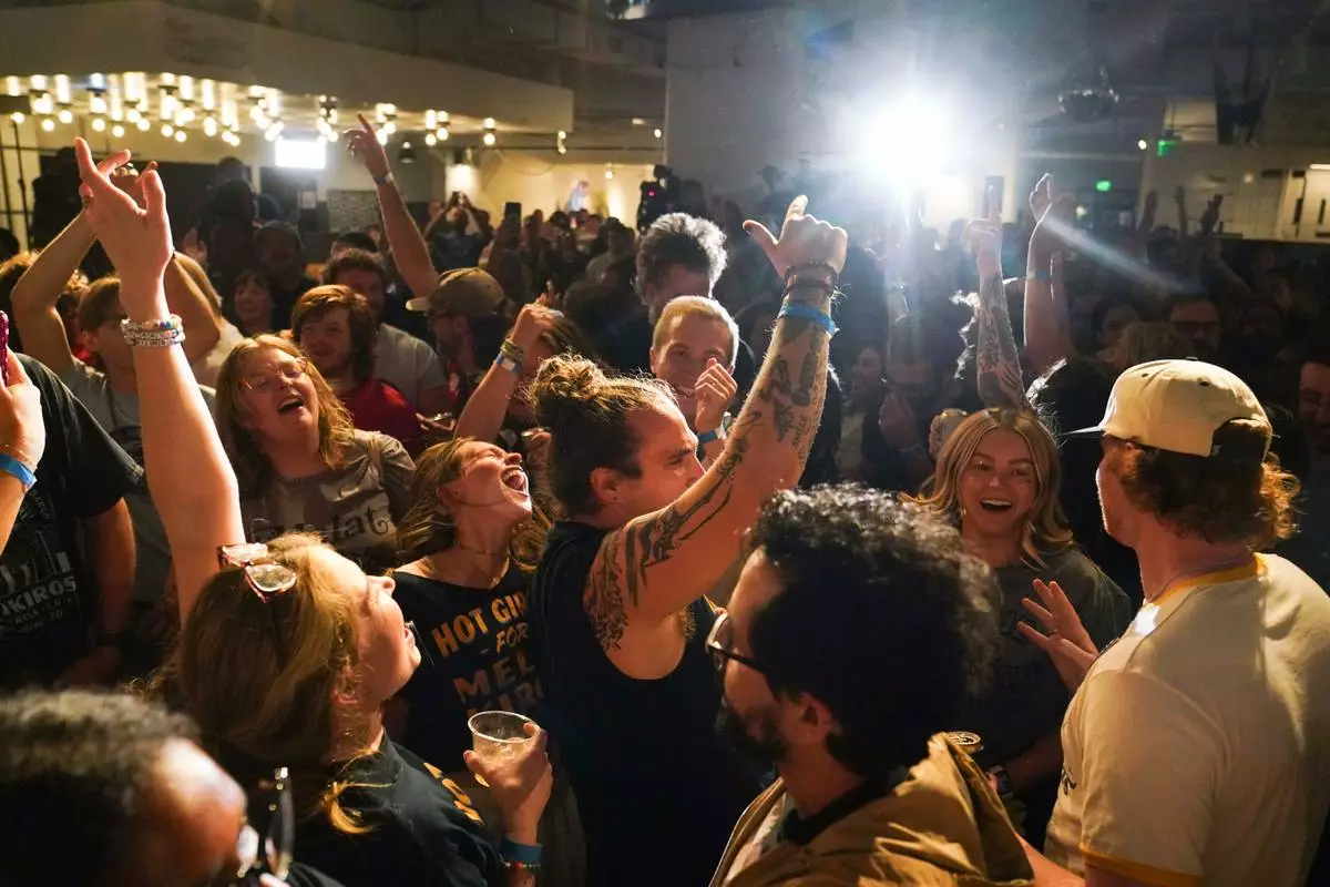 Supporters dance after the second round of results came in with Democratic congressional candidate Melat Kiros leading during a primary election night watch party at The Broadway, Tuesday, June 30, 2026, in Denver. (AP Photo/Rebecca Slezak)