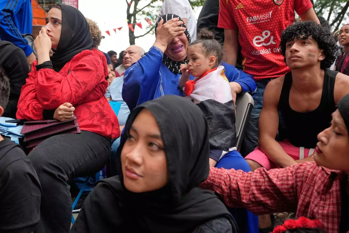 Egyptian fans, including Faten Moussa, center in blue, react towards the end of a World Cup soccer game against Argentina, in New York, Tuesday, July 7, 2026. (AP Photo/Seth Wenig)