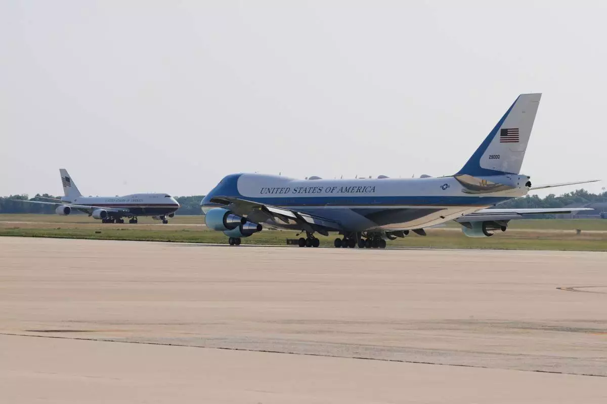 The newly designated Air Force One, left, with president Donald Trump on board, takes off on the runway as the old version of the plane is in the foreground, at Joint Base Andrews, Md., Wednesday, July 1, 2026 (AP Photo/Luis M. Alvarez)