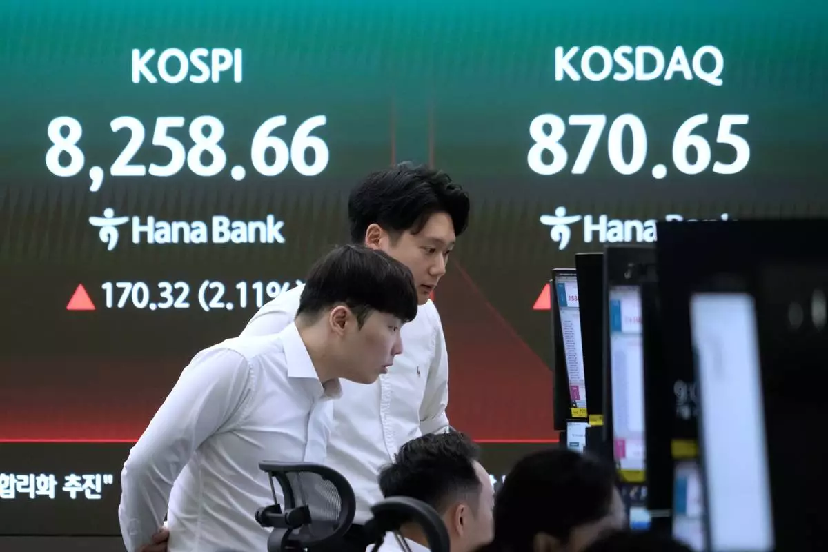 Currency traders watch monitors near a screen showing the Korea Composite Stock Price Index (KOSPI) at the foreign exchange dealing room of the Hana Bank headquarters in Seoul, South Korea, Monday, July 6, 2026. (AP Photo/Ahn Young-joon)