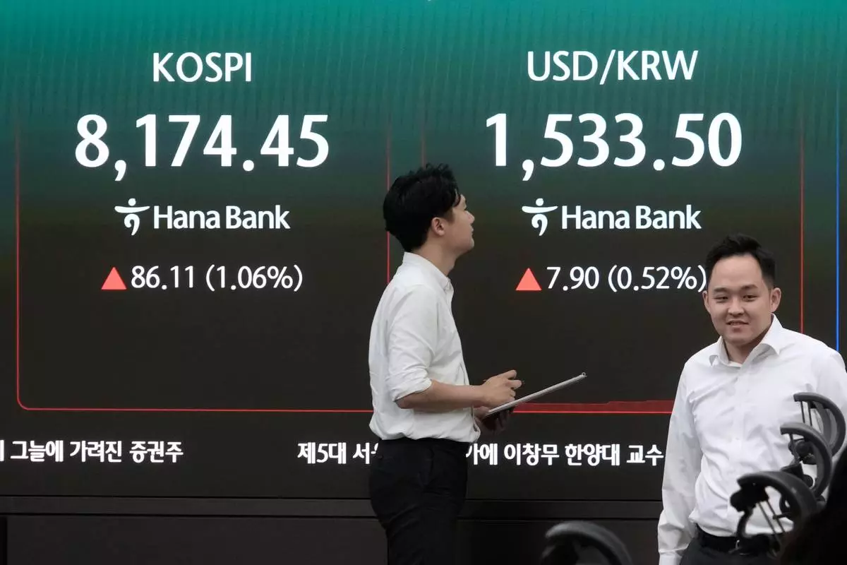 Currency traders pass by a screen showing the Korea Composite Stock Price Index (KOSPI) and the foreign exchange rate between U.S. dollar and South Korean won at the foreign exchange dealing room of the Hana Bank headquarters in Seoul, South Korea, Monday, July 6, 2026. (AP Photo/Ahn Young-joon)