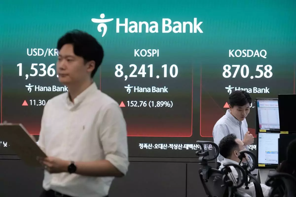 Currency traders work near a screen showing the Korea Composite Stock Price Index (KOSPI) and the foreign exchange rate between U.S. dollar and South Korean won at the foreign exchange dealing room of the Hana Bank headquarters in Seoul, South Korea, Monday, July 6, 2026. (AP Photo/Ahn Young-joon)