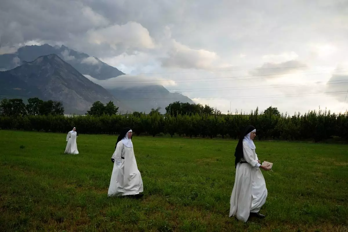 Nuns make their way to a tent set up outside the Society of St. Pius X seminary to attend a consecration ceremony for four new bishops in Econe, Switzerland, Wednesday, July 1, 2026. (AP Photo/Baz Ratner)