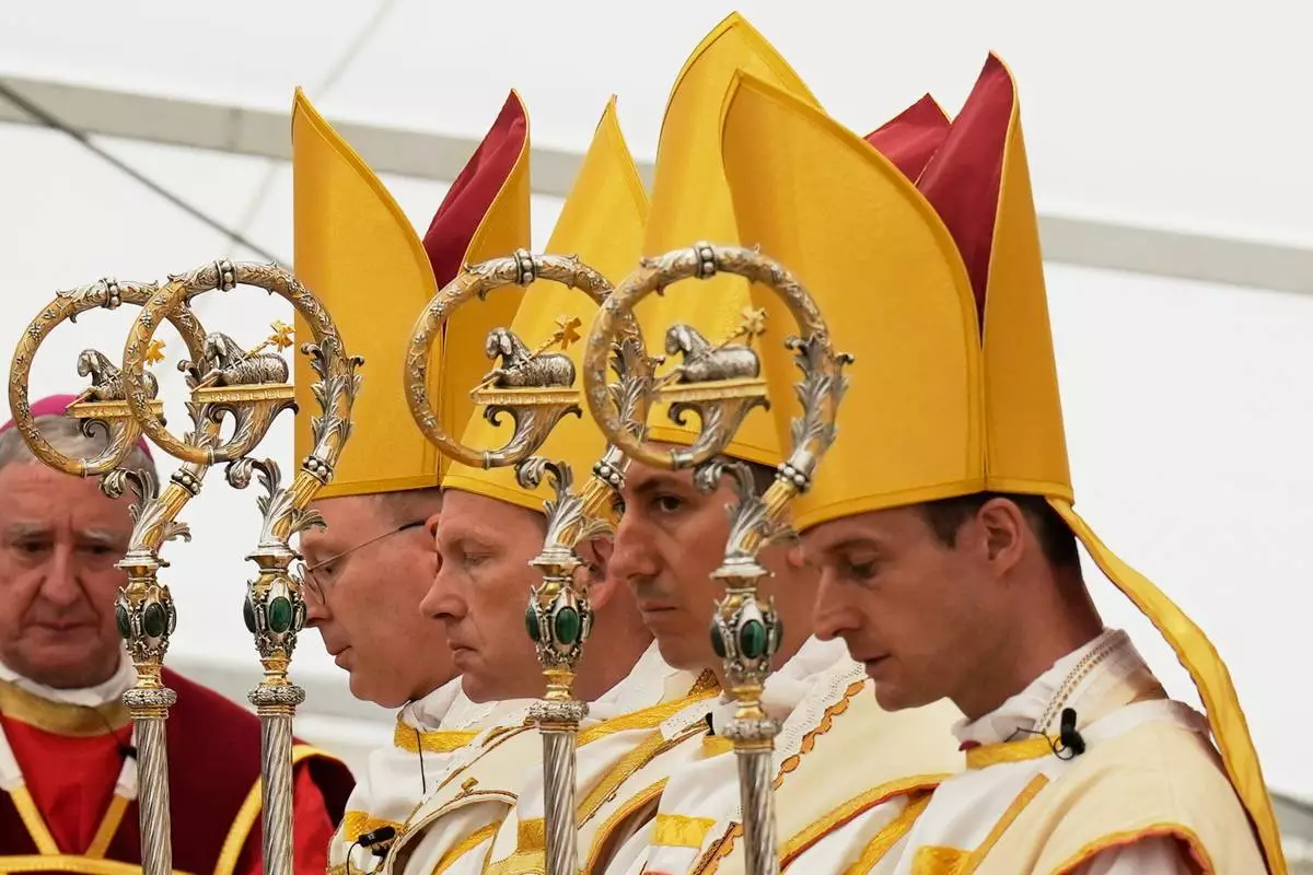 Newly consecrated Bishops, from left, Pascal Schreiber, Michael Goldade, Michel Poinsinet de Sivry and Marc Hanappier, wearing their miters and holding their pastoral staffs, pray at the end of their consecration ceremony in a tent set up outside the Society of St. Pius X seminary in Econe, Switzerland, Wednesday, July 1, 2026. (AP Photo/Baz Ratner)