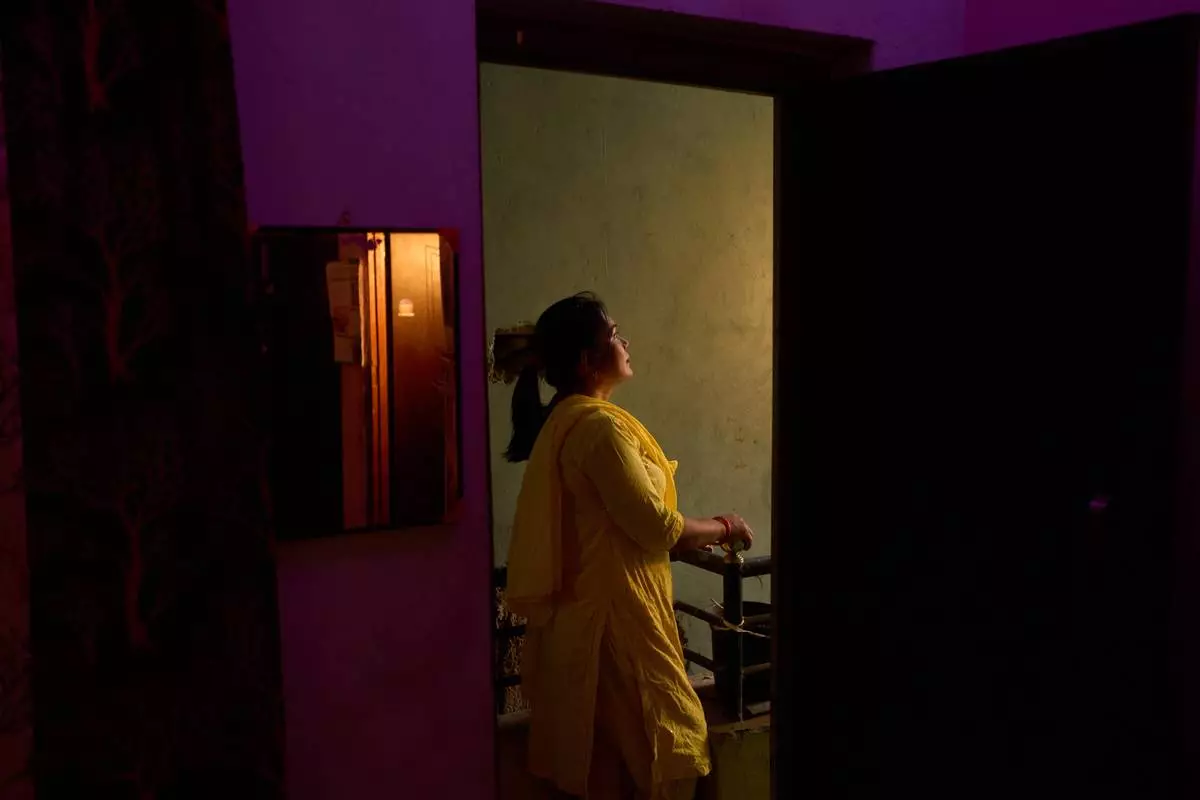 Bharati Thapa, a former HIV outreach worker who turned to sex work to survive after losing her job amid the U.S. foreign aid cuts, poses for a portrait outside the office of her former NGO, Wednesday, May 20, 2026, in Hetauda, Nepal. Thapa, who suffered a gang rape on her first night as a sex worker, says she fears her new line of work will kill her. (AP Photo/Bram Janssen)