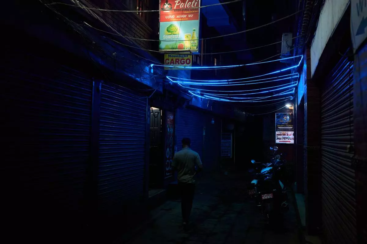 A man walks down an alley in a bustling neighborhood of Kathmandu, Nepal, Thursday, May 21, 2026. (AP Photo/Bram Janssen)