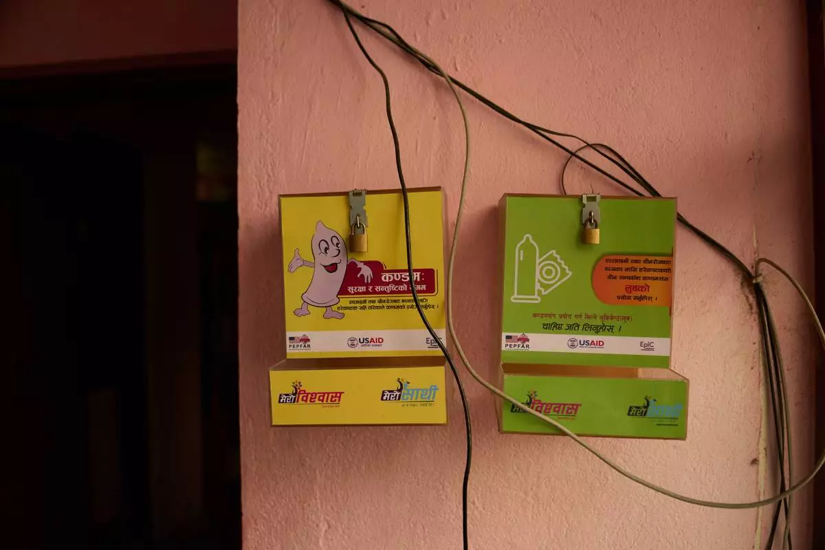 An empty condom dispenser hangs outside an office in Kathmandu, Nepal, Tuesday, May 12, 2026. (AP Photo/Bram Janssen)