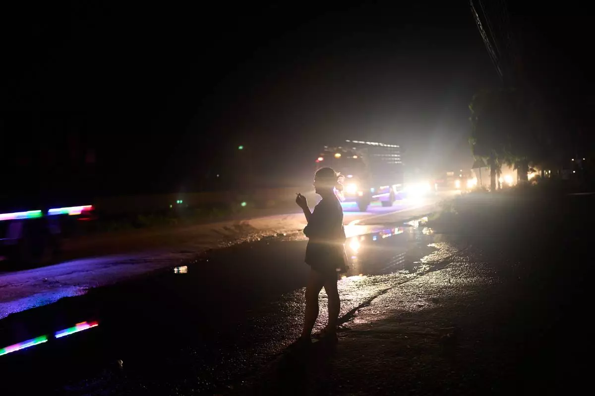 A transgender sex worker stands next to a busy highway waiting for clients to approach her in Hetauda, Nepal, Saturday, May 16, 2026. (AP Photo/Bram Janssen)