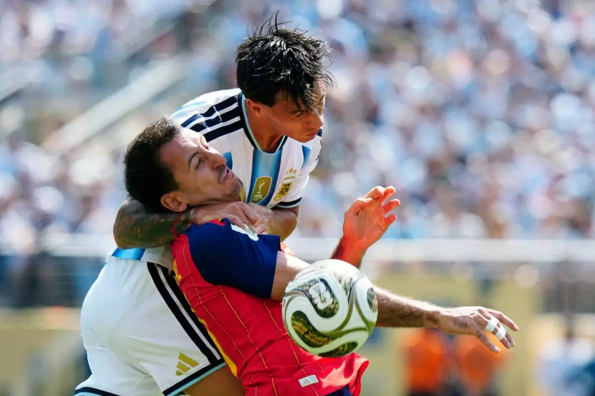 Argentina defender Lisandro Martínez (6) and Spain midfielder Mikel Oyarzabal (21) vie for the ball during first half FIFA World Cup final action, in East Rutherford, N.J., on Saturday, July 19, 2026. (Frank Gunn/The Canadian Press via AP)