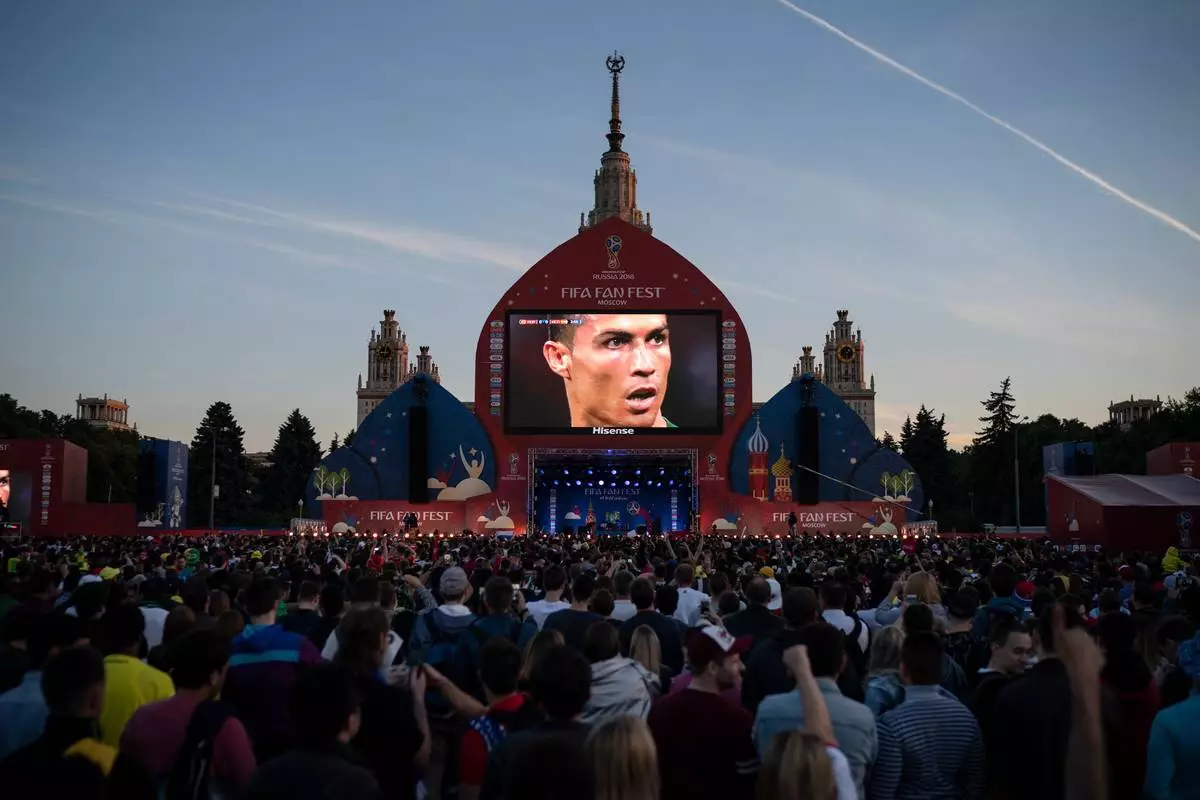 FILE - Fans watch on a giant screen as Portugal's Cristiano Ronaldo prepares to kick a penalty during the group B match between Portugal and Spain, at the FIFA Fan Fest in Moscow, Russia, June 15, 2018. (AP Photo/Felipe Dana, File)