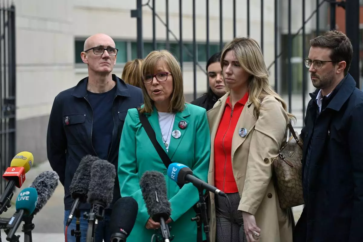 Lyra McKee's sister Nichola Corner, center, speaks to the media outside Belfast Crown Court in Belfast, Ireland, where Paul McIntyre, Peter Cavanagh and Jordan Gareth Devine have been found not guilty in a non-jury trial of the murder of journalist Lyra McKee, Friday July 3, 2026. (PA via AP)