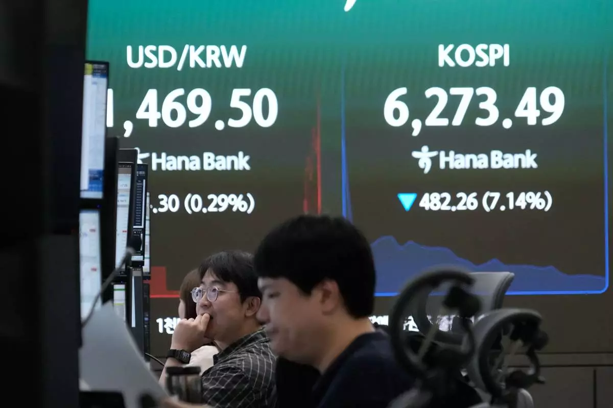 Currency traders watch monitors near a screen showing the Korea Composite Stock Price Index (KOSPI) and the foreign exchange rate between U.S. dollar and South Korean won at the foreign exchange dealing room of the Hana Bank headquarters in Seoul, South Korea, Tuesday, July 28, 2026. (AP Photo/Ahn Young-joon)