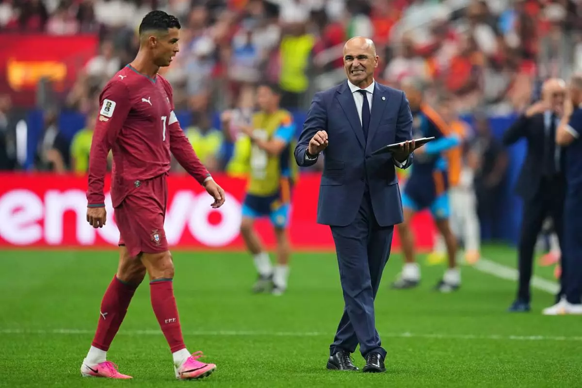 Portugal head coach Roberto Martinez, right, gives instructions to Cristiano Ronaldo (7) during the World Cup round of 16 soccer match between Portugal and Spain in Arlington, Texas, near Dallas, Monday, July 6, 2026. (AP Photo/Julio Cortez)