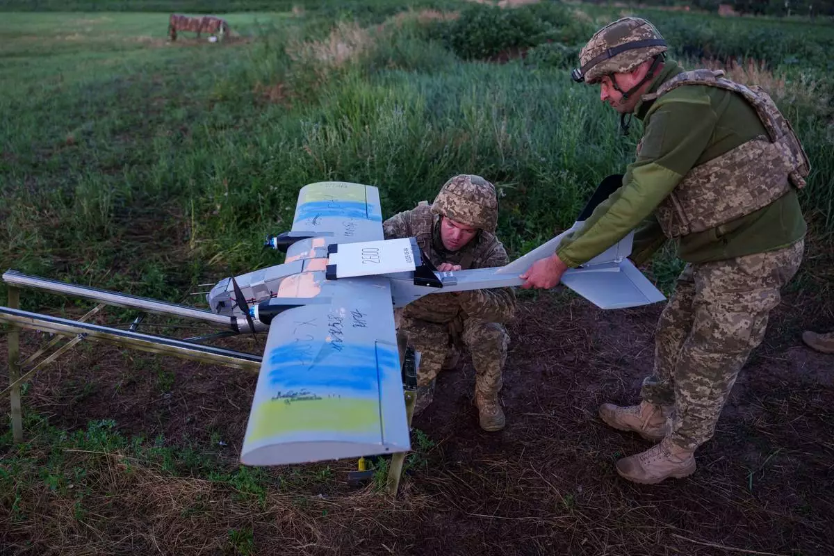 Ukrainian servicemen of K-2 brigade of the Unmanned Systems Forces prepare a midrange drone at takeoff position before flying towards Russian positions at the frontline in Donetsk region, Ukraine, Monday, June 22, 2026. (AP Photo/Evgeniy Maloletka)