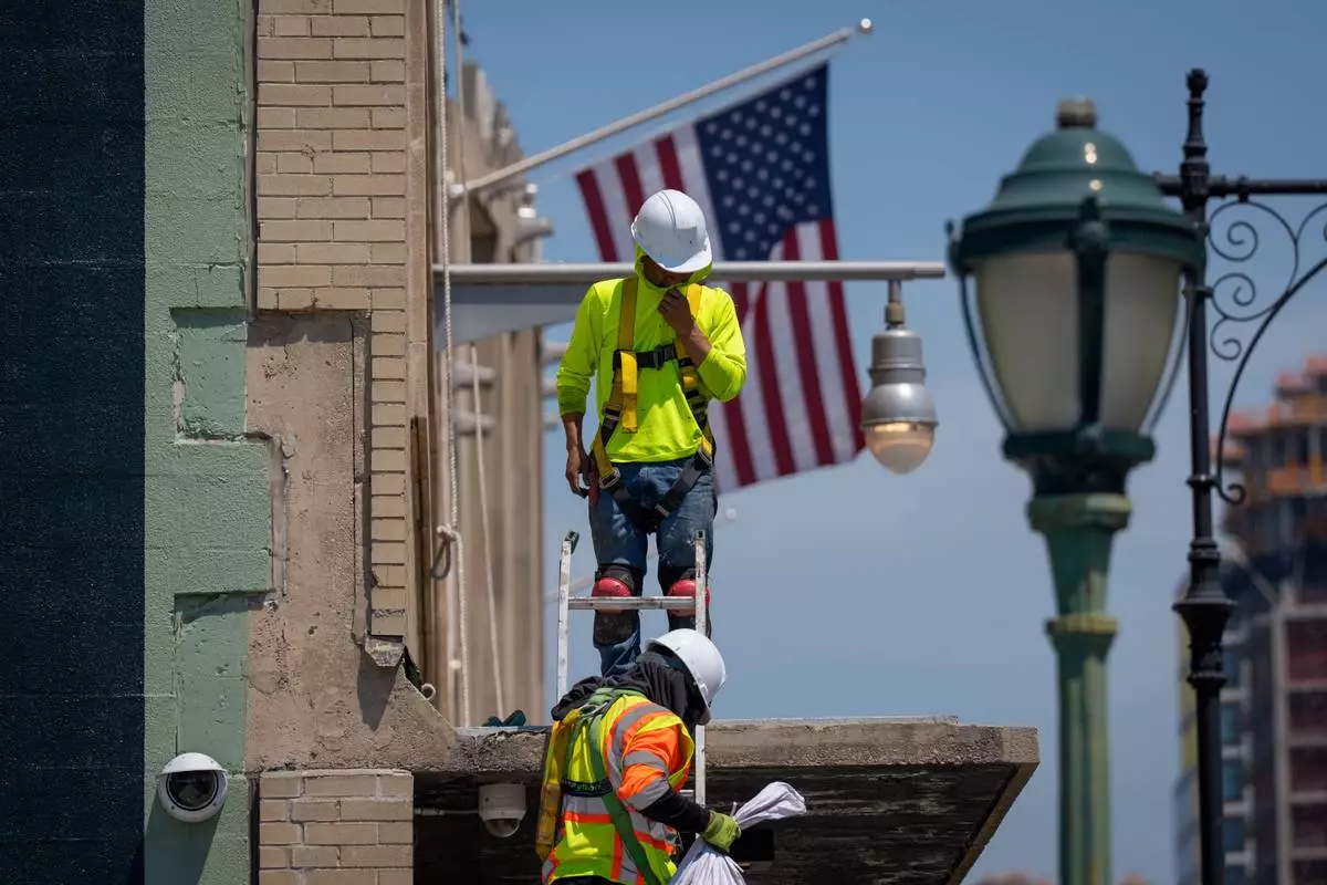 FILE - Workers climb down from a building during a heat advisory, May 19, 2026, in New York. (AP Photo/Adam Gray, File)