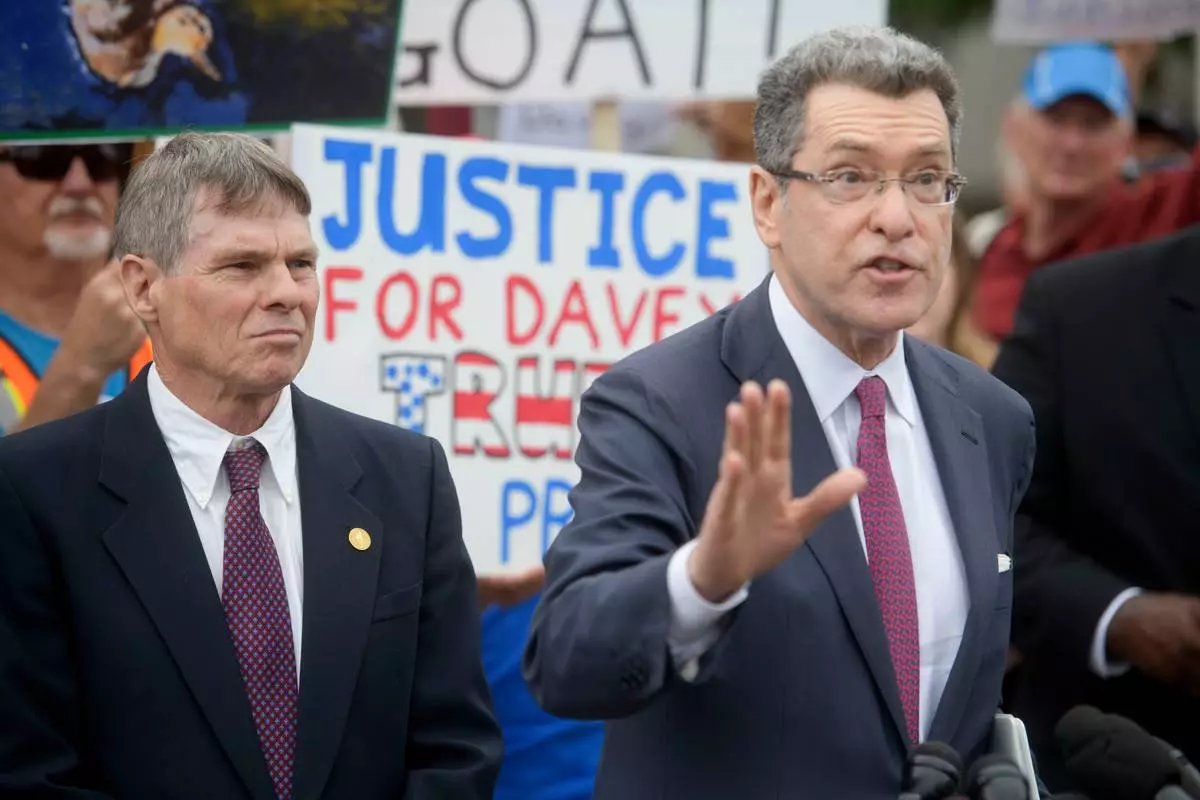 Former Olympic canoeist David Hearn, left, listens as his attorney Norman Eisen, right, speaks after he pleaded not guilty to allegedly damaging the Lincoln Memorial Reflecting Pool, Thursday, July 9, 2026, in Washington. (AP Photo/Rod Lamkey, Jr.)