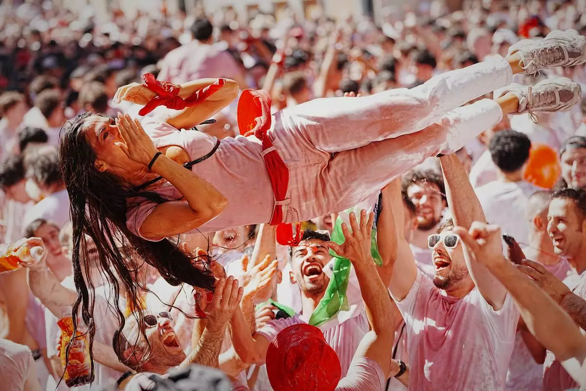 Revelers celebrate as the txupinazo, the traditional rocket marking the start of the San Fermín festival, kicks off nine days of uninterrupted festivities in Pamplona, Spain, Monday, July 6, 2026. (AP Photo/Miguel Oses)