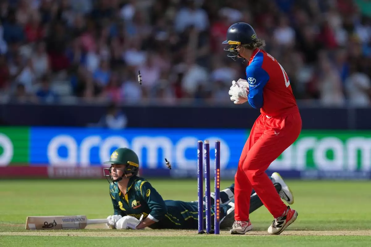 Australia's Phoebe Litchfield, makes her ground as England's wicketkeeper Amy Jones, attempts a run out during the Women's T20 Cricket World Cup final between England and Australia in London, Sunday, July 5, 2026. (AP Photo/Alastair Grant)