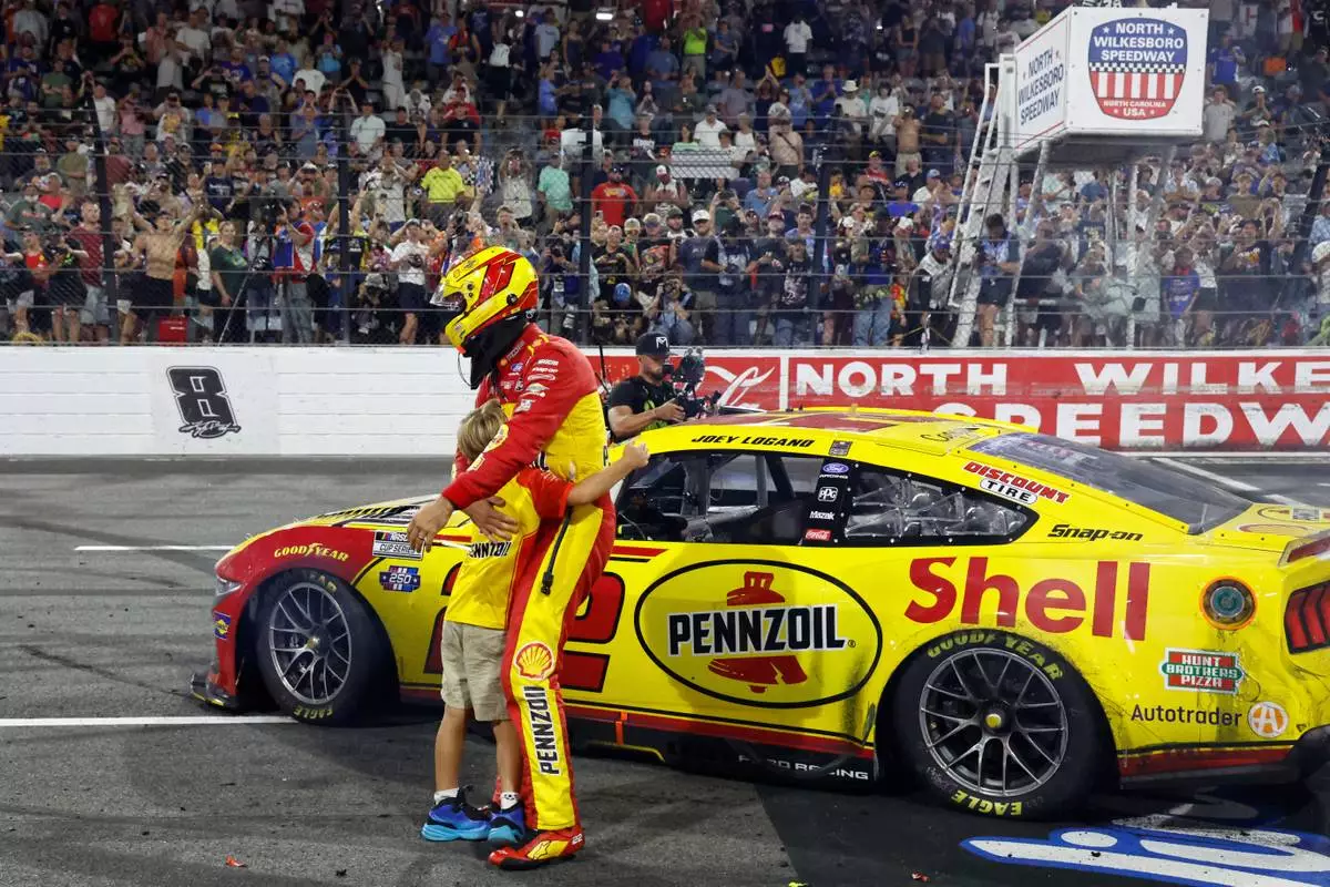 Joey Logano hugs his son Hudson after winning a NASCAR Cup Series auto race in North Wilkesboro, N.C., Sunday, July 19, 2026. (AP Photo/Terry Renna)