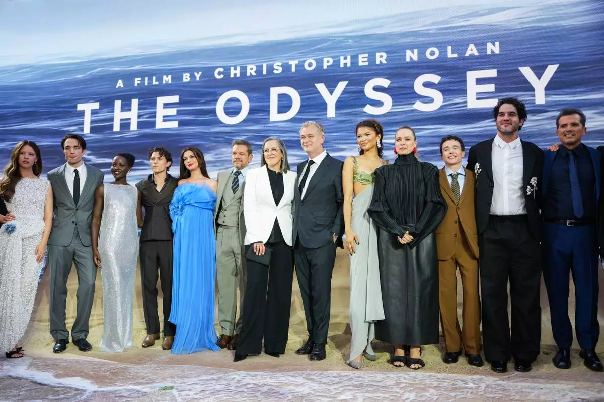Mia Goth, from left, Robert Pattinson, Lupita Nyong'o, Tom Holland, Anne Hathaway, Matt Damon, Emma Thomas, Christopher Nolan, Zendaya, Samantha Morton, Elliot Page, Benny Safdie, and John Leguizamo pose for photographers upon arrival at the premiere of the film 'The Odyssey' on Monday, July 6, 2026, in London. (Photo by Scott A Garfitt/Invision/AP)
