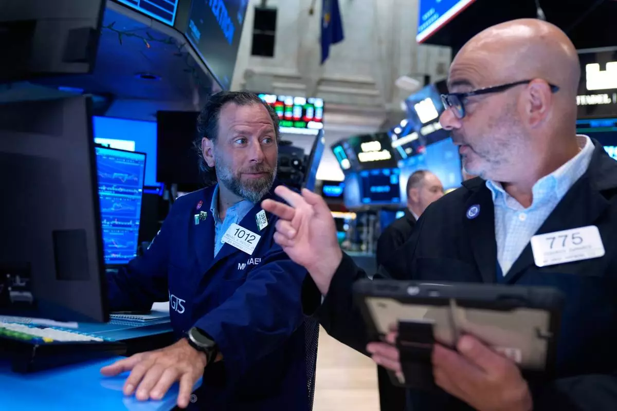 Michael Pistillo, left, and Federico DeMarco work on the floor at the New York Stock Exchange in New York, Monday, July 6, 2026. (AP Photo/Seth Wenig)