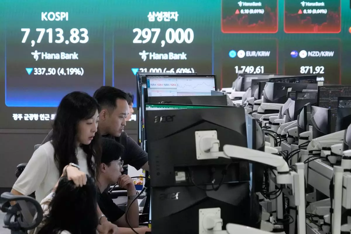 Currency traders watch monitors near a screen showing the Korea Composite Stock Price Index (KOSPI) at the foreign exchange dealing room of the Hana Bank headquarters in Seoul, South Korea, Tuesday, July 7, 2026. (AP Photo/Ahn Young-joon)