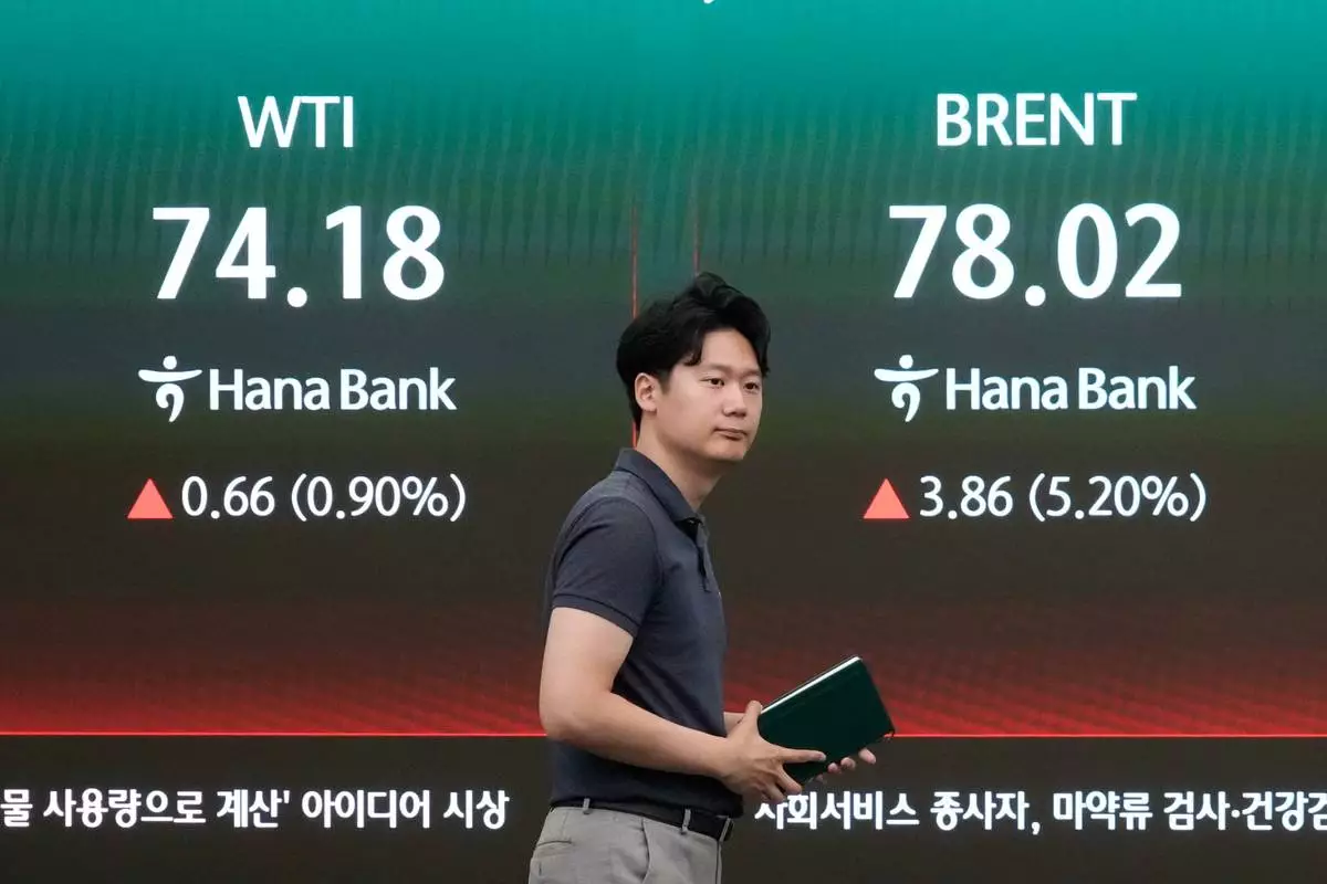 A currency trader passes by a screen showing international oil prices at the foreign exchange dealing room of the Hana Bank headquarters in Seoul, South Korea, Thursday, July 9, 2026. (AP Photo/Ahn Young-joon)