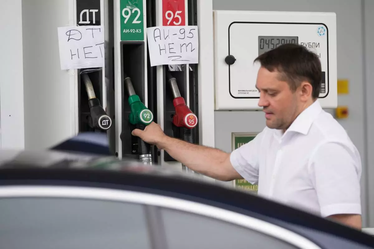 A man fills up a tank of his car as signs reading in Russian "No diesel" and "No premium gasoline" are seen on gas pump nozzles at a Tatneft gas station in Moscow, Monday, June 29, 2026. (AP Photo/Pavel Bednyakov)