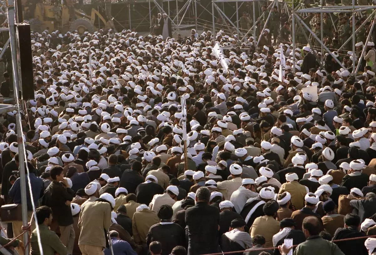 FILE - Mourners crowd around the grave of the late Ayatollah Khomeini at the cemetery in Beheshte e Zahra, some 70 kms from Tehran, Iran, June 11, 1989. (AP Photo/Heribert Proepper, File)