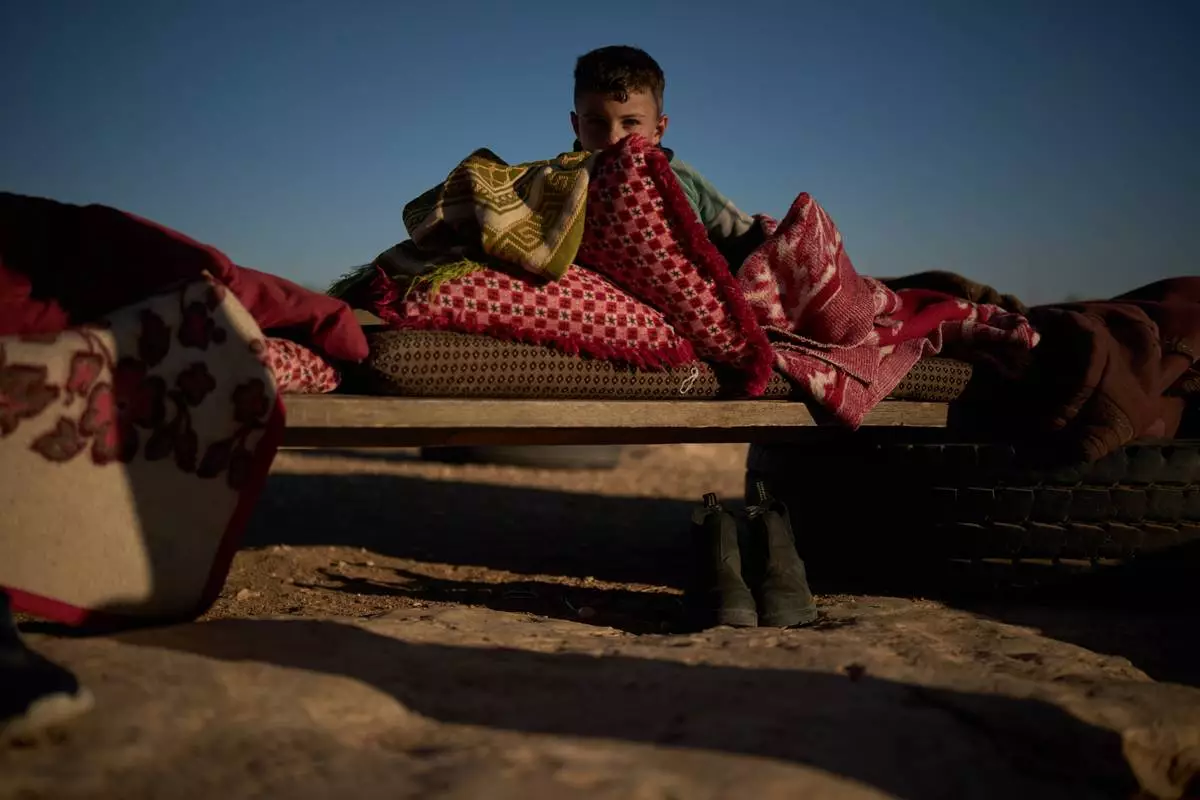 Yasser, 8, looks at the camera after taking a nap in the morning outside his house in a Palestinian community near the West Bank village of Susya, in the Masafer Yatta region, Thursday, June 18, 2026. (AP Photo/Leo Correa)