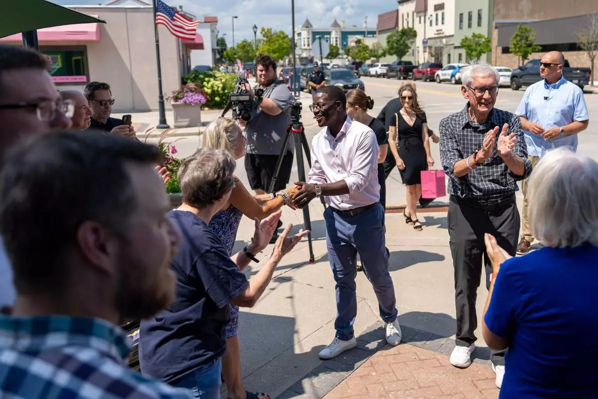 David Crowley, Democratic candidate for Wisconsin governor, shakes hands with supporters while campaigning with Wisconsin Gov. Tony Evers, right, Friday, Aug. 7, 2026, in Sheboygan, Wis. (AP Photo/Kayla Wolf)