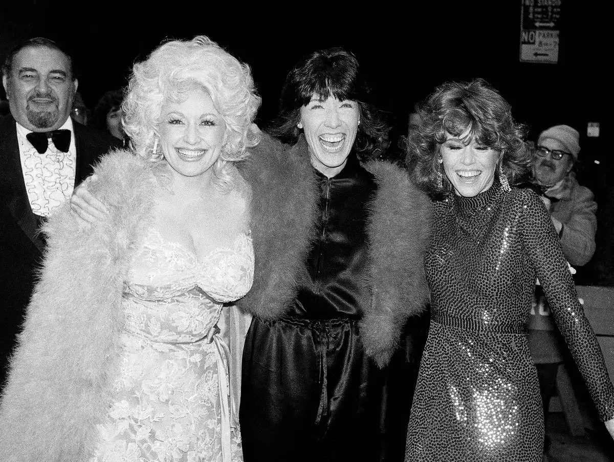 FILE - Dolly Parton, left, Lily Tomlin, center, and Jane Fonda arrive for the premiere of their film "9 To 5" in New York on Dec. 14, 1980. (AP Photo/Richard Drew, File) Corrects spelling from Jan to Jane.