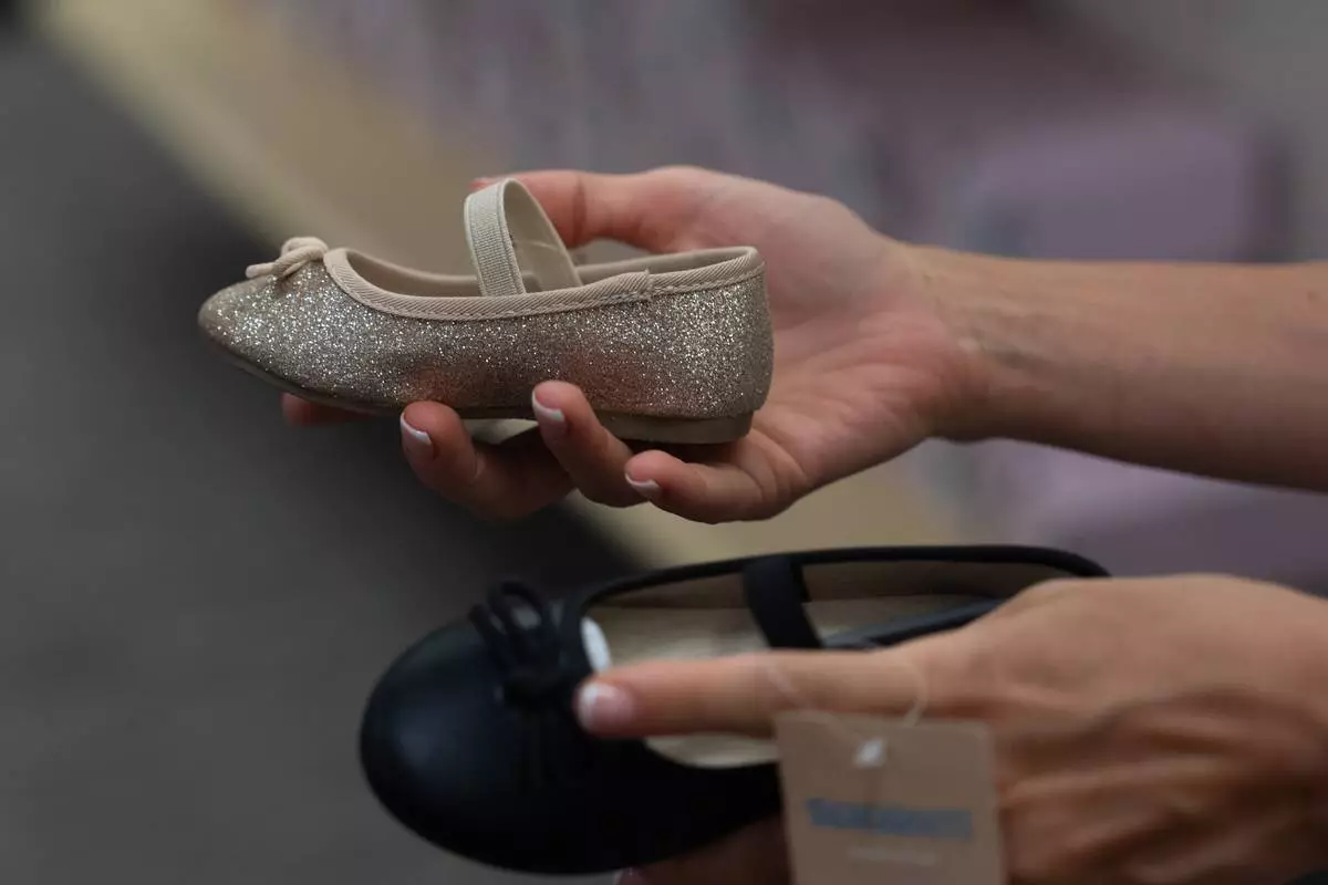 Khrystyna Lialina shops for shoes for her daughter at a JCPenney store in Glendale, Calif., Tuesday, Aug. 11, 2026. (AP Photo/Jae C. Hong)