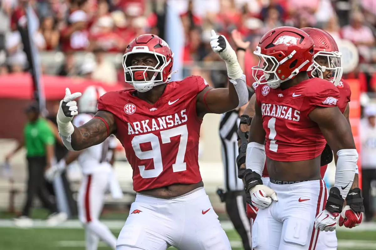 FILE - Arkansas defenders Quincy Rhodes Jr. (97) and Phillip Lee (1) celebrate after a big defensive stop against Arkansas State during an NCAA football game, Sept. 6, 2025, in Little Rock, Ark. (AP Photo/Michael Woods, File)