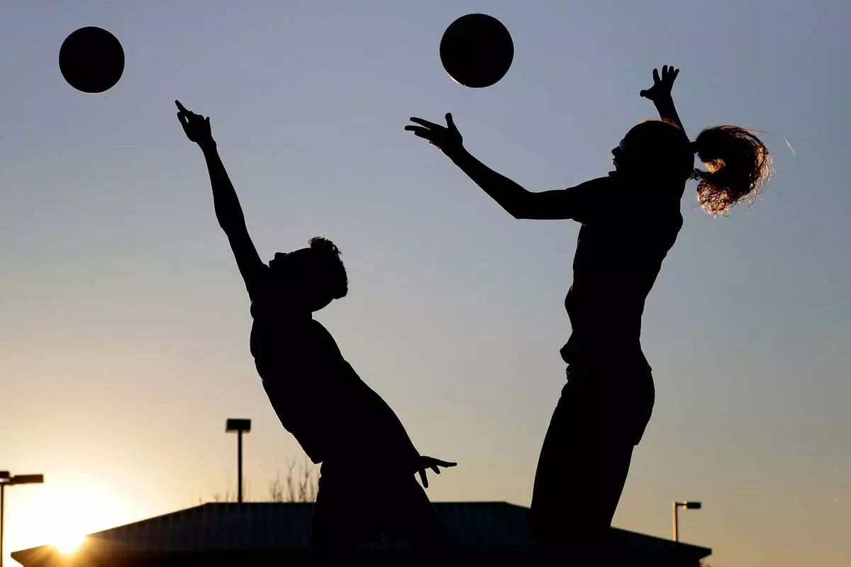 FILE - Friends practice volleyball at a local park in Gilbert, Ariz., March 15, 2020. (AP Photo/Matt York, File)