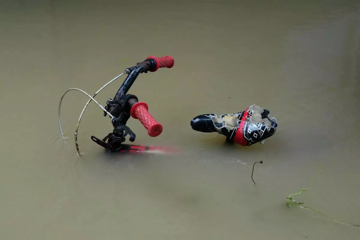 A bike is parked along floodwaters caused by heavy seasonal monsoon rains at Bagong Silangan village in Quezon city, Metro Manila, Philippines Monday, Aug. 10, 2026. (AP Photo/Aaron Favila) CORRECTION: Corrects typo in location to Silangan, instead of Silagan