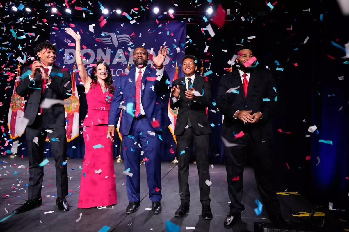 Florida Republican gubernatorial candidate Byron Donalds, center, waves next to his wife Erika, while standing on stage with their children Darin, left, Damon, second from left, and Mason during at a primary election party Tuesday, Aug. 18, 2026, in Orlando, Fla. (AP Photo/John Raoux)