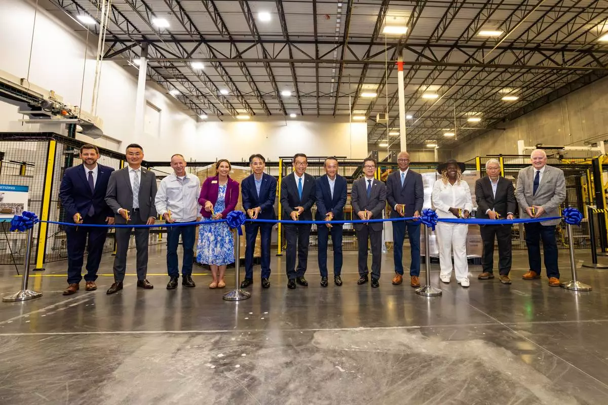 Attendees participate in a ribbon-cutting ceremony to celebrate the completion of the facility.