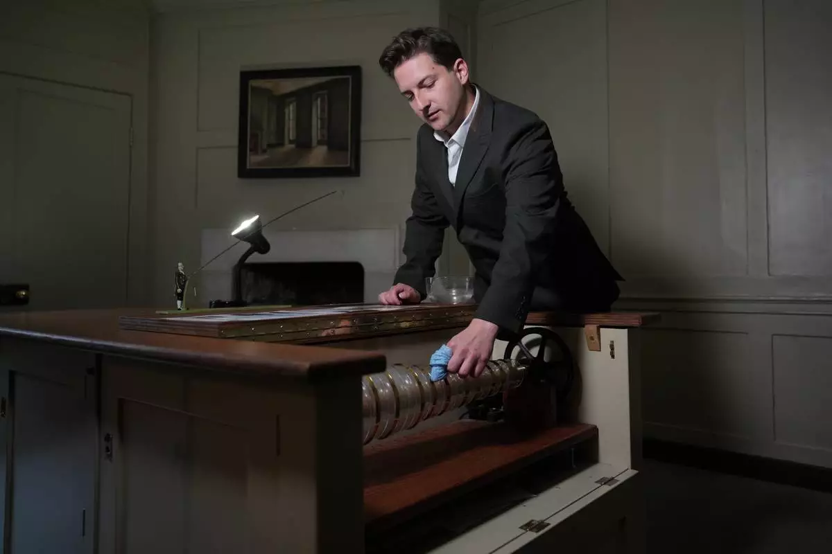 Henry Wilkinson, head of education at the Benjamin Franklin House, shows a replica of Franklin's armonica at the Benjamin Franklin House in London, Monday, May 11, 2026. (AP Photo/Kin Cheung)